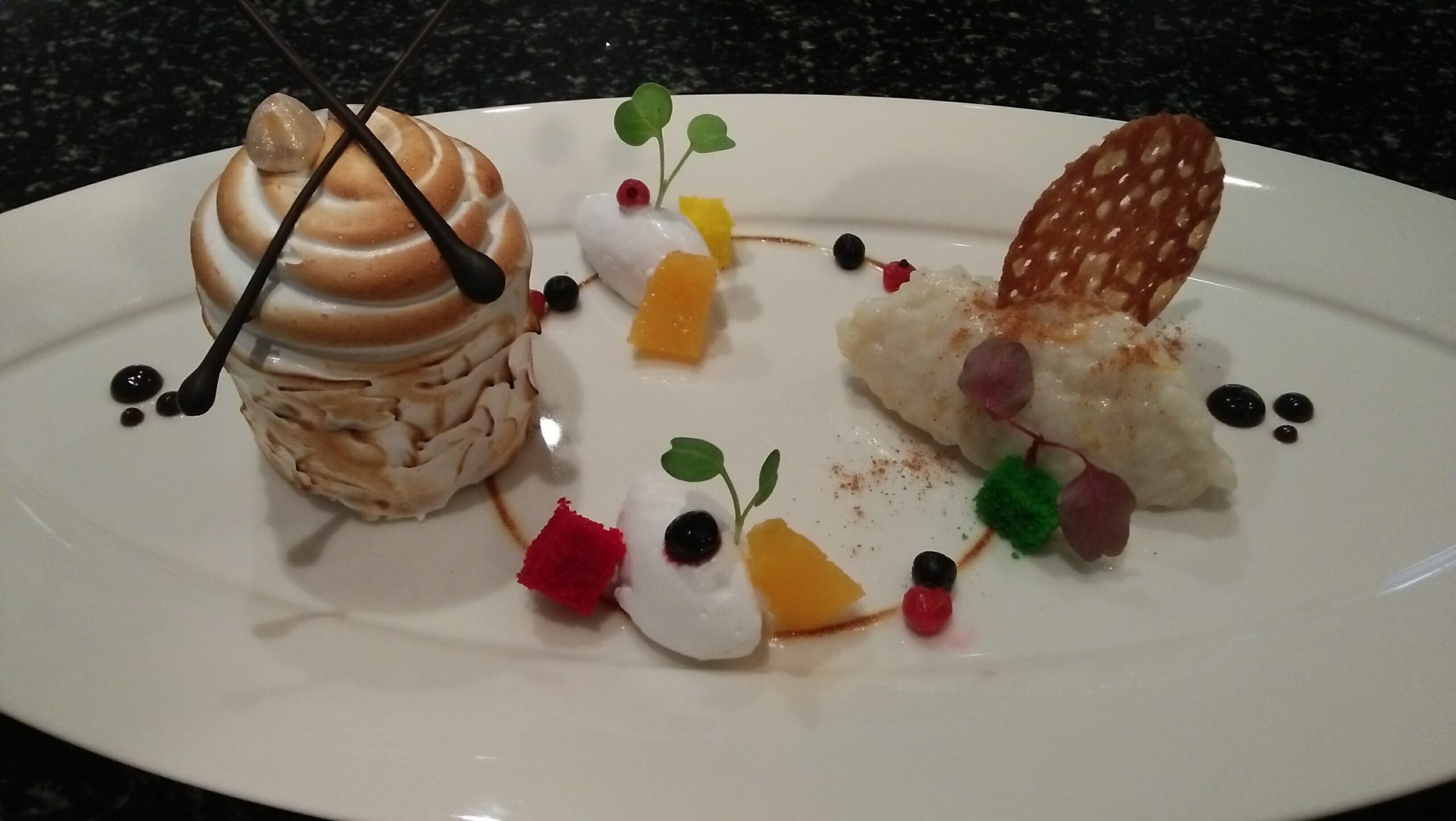 Elegant plated fusion dessert with delicate garnish from hotel pastry kitchen