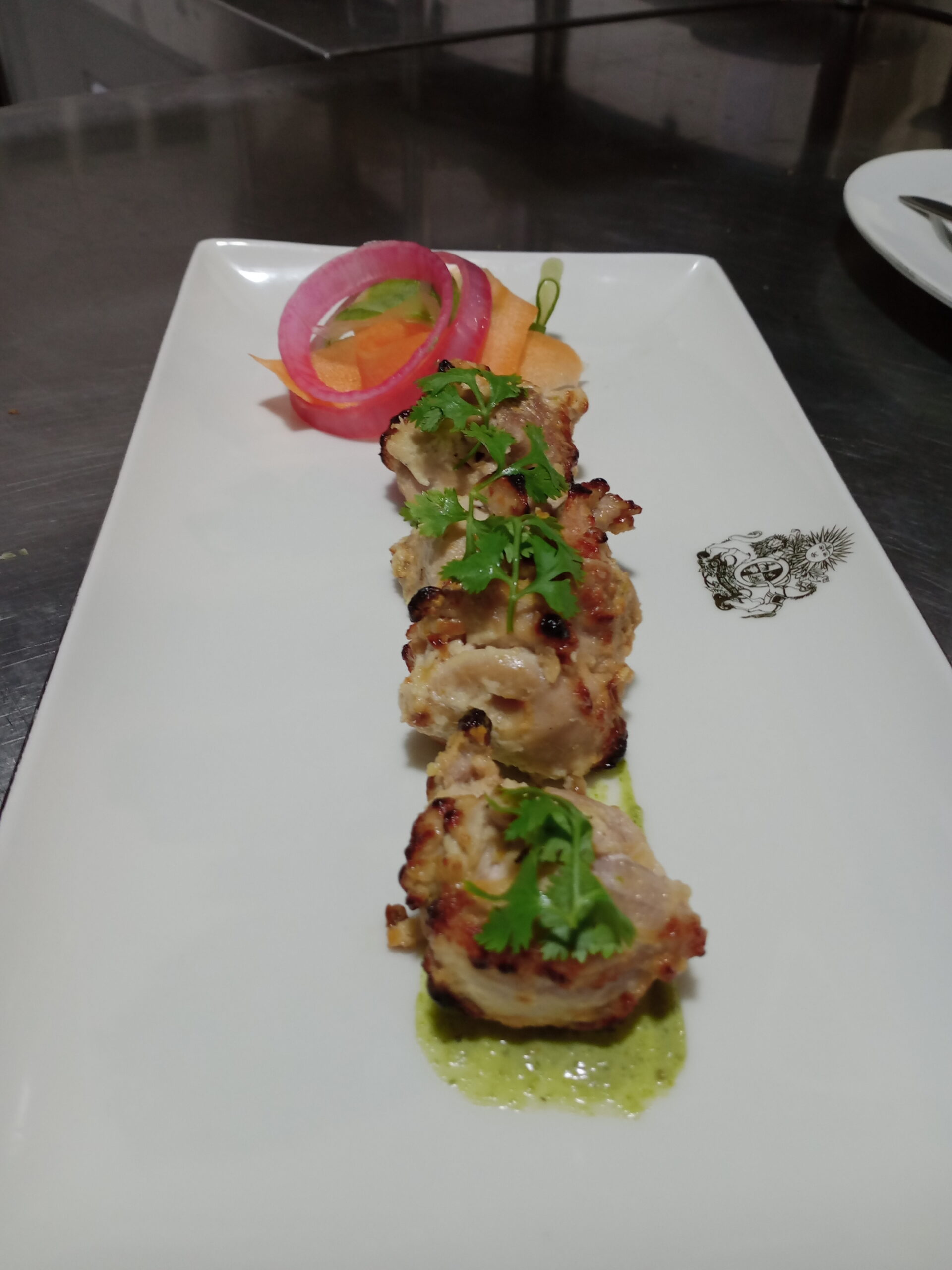Modern plated Indian food — grilled tikka with green chutney and garnish