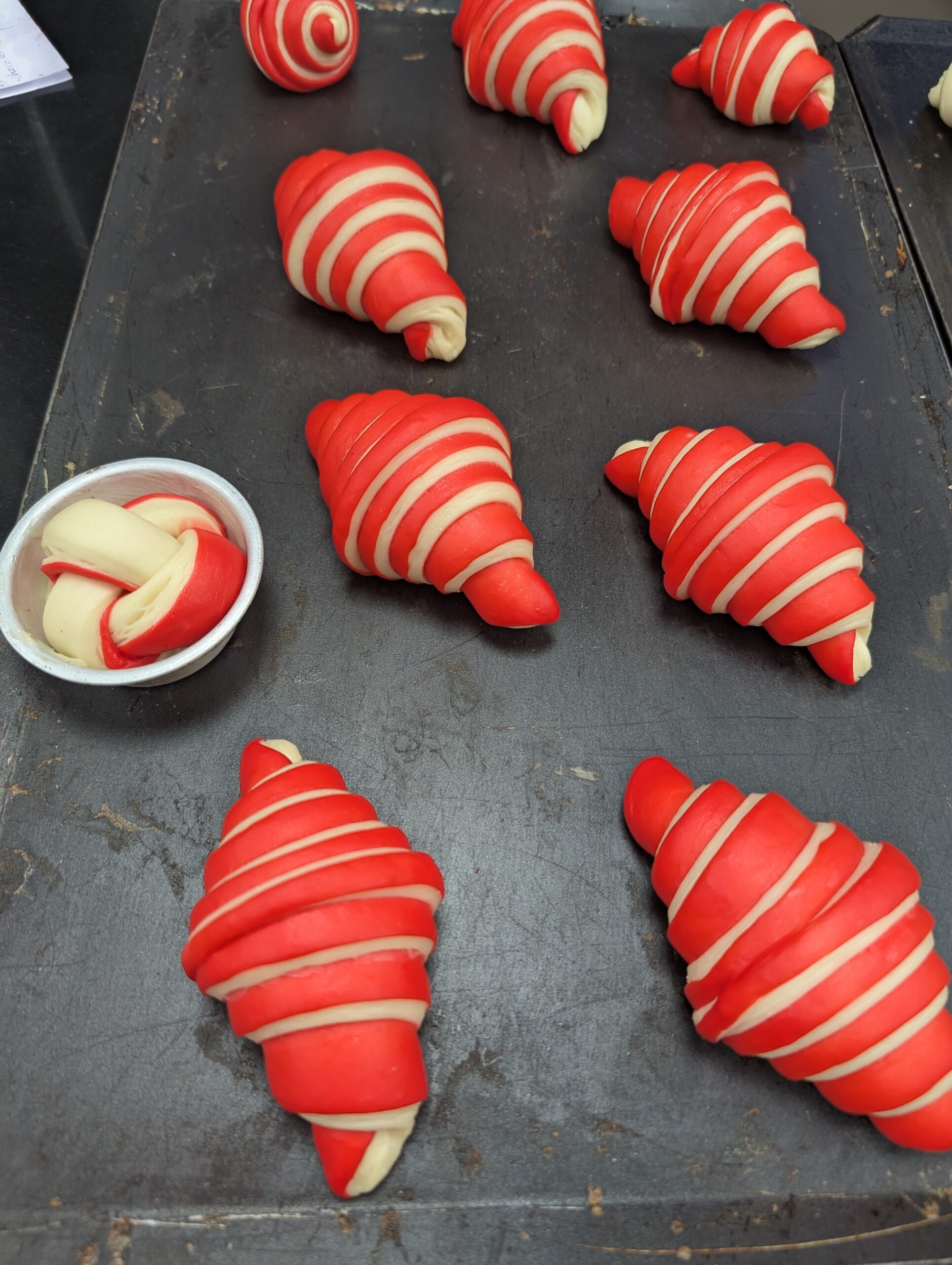 Freshly shaped croissants on a baking tray ready for the oven