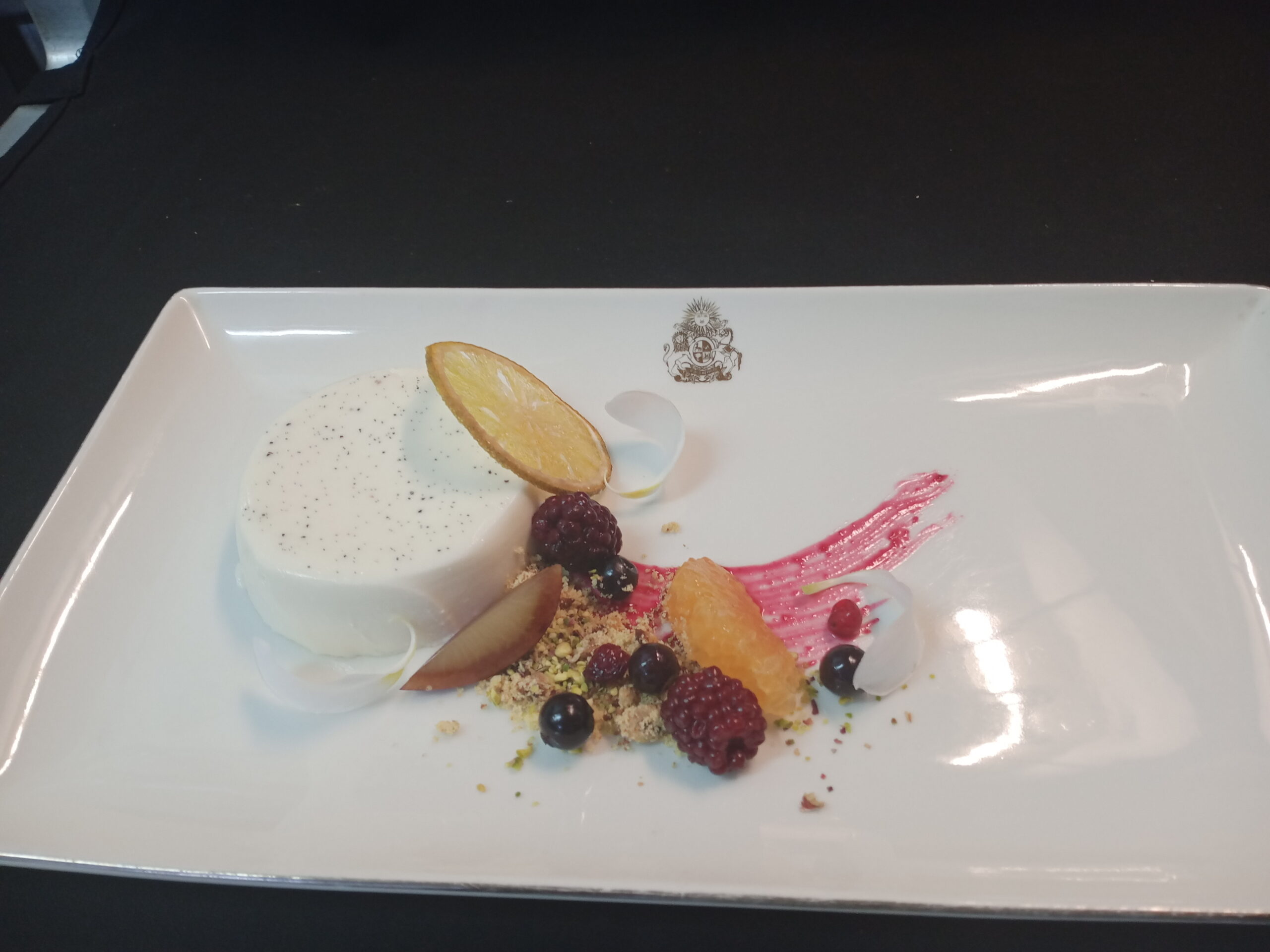Classic vanilla panna cotta with berry compote and citrus garnish