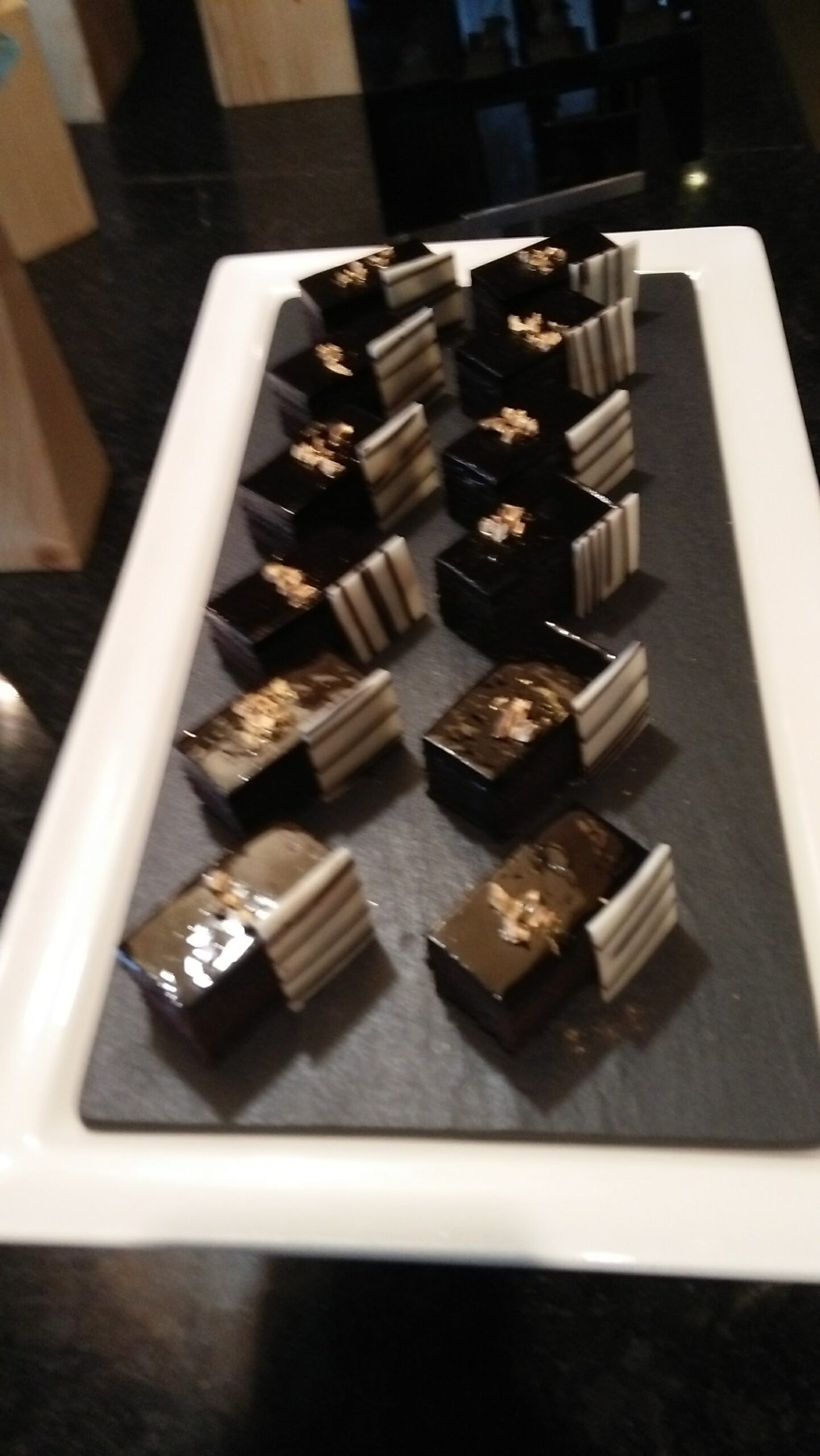 Elegant petit fours with glossy glaze on a hotel pastry tray